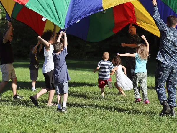 Kids running under parachute